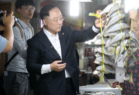 홍남기 부총리 겸 기획재정부 장관이 9일 오후 충남 공주 산성시장을 찾아 복지시설에서 생활하는 청소년들이 먹을 음식을 사고 있다. <연합뉴스>